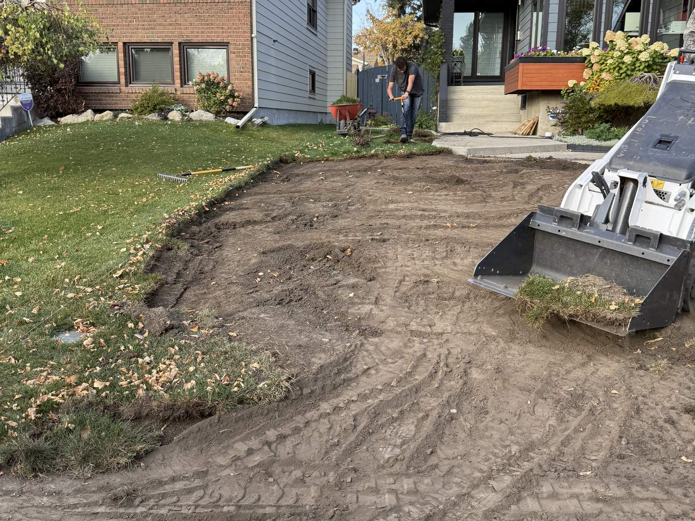 Beddington Heights front yard with the old lawn already stripped out and our Bobcat MT100 at work