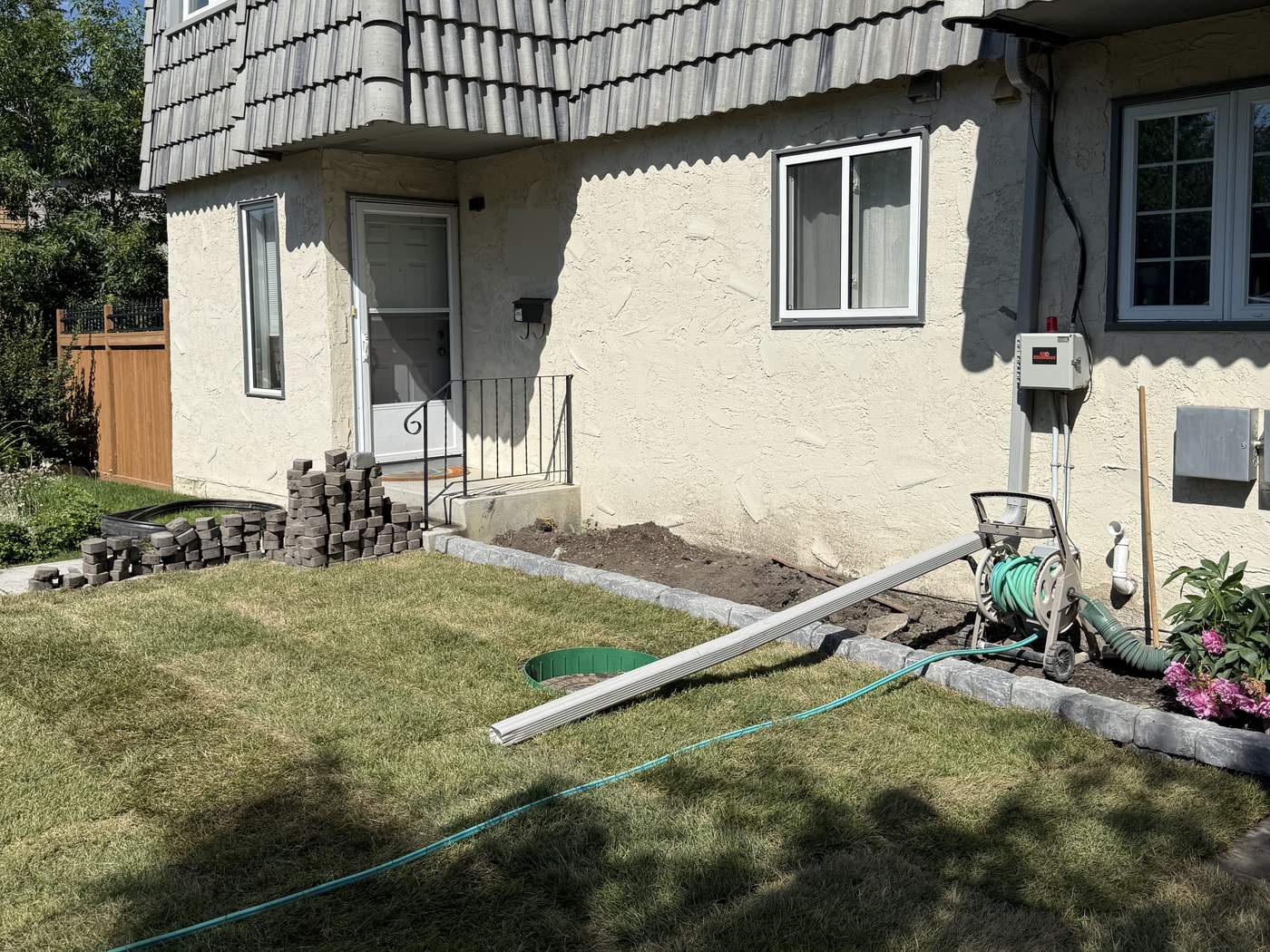 The same wall and doorway after, the regraded lawn in new sod