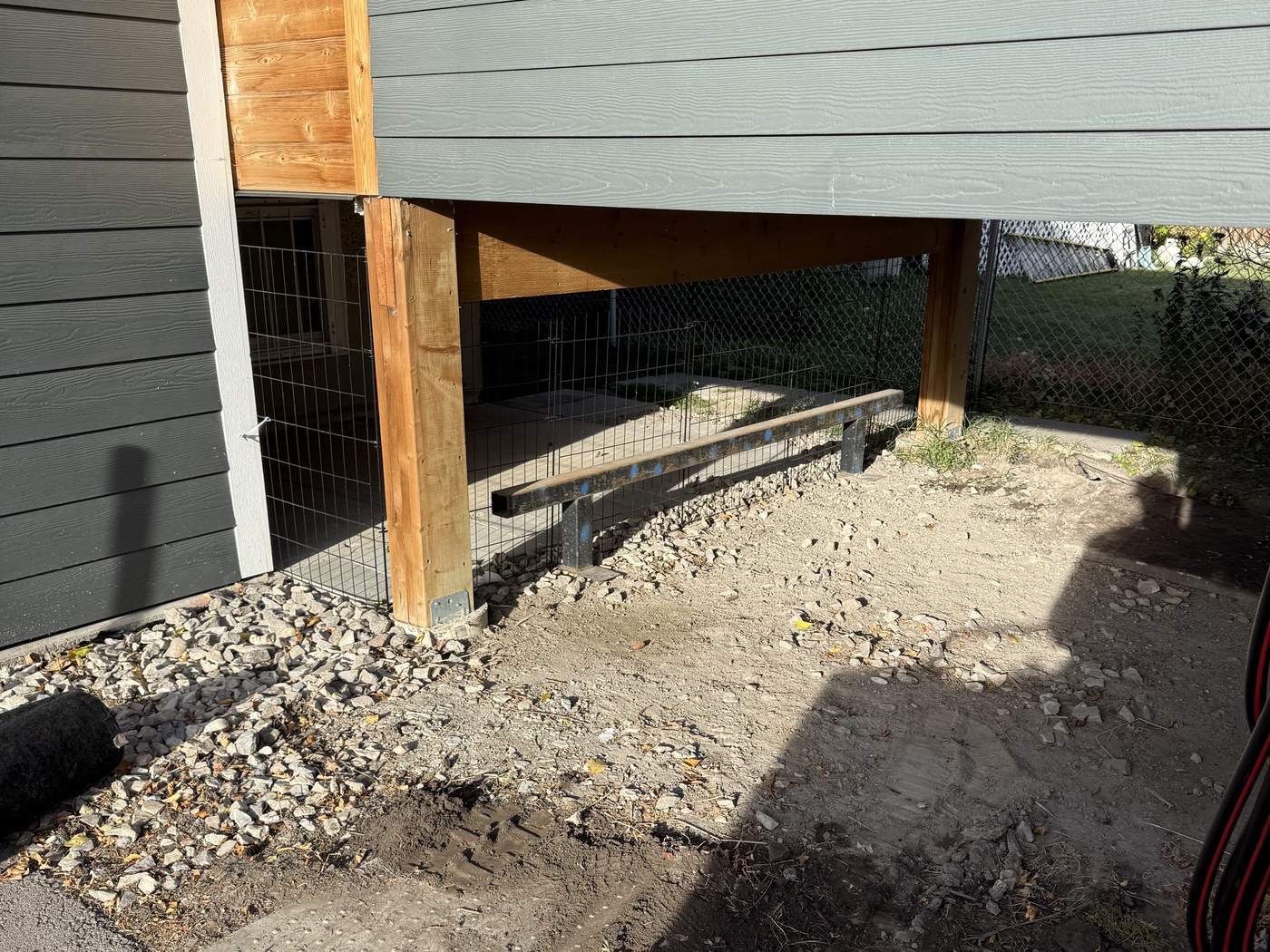 The ground under a Montgomery deck dug out to bare soil, old rock pushed to one side