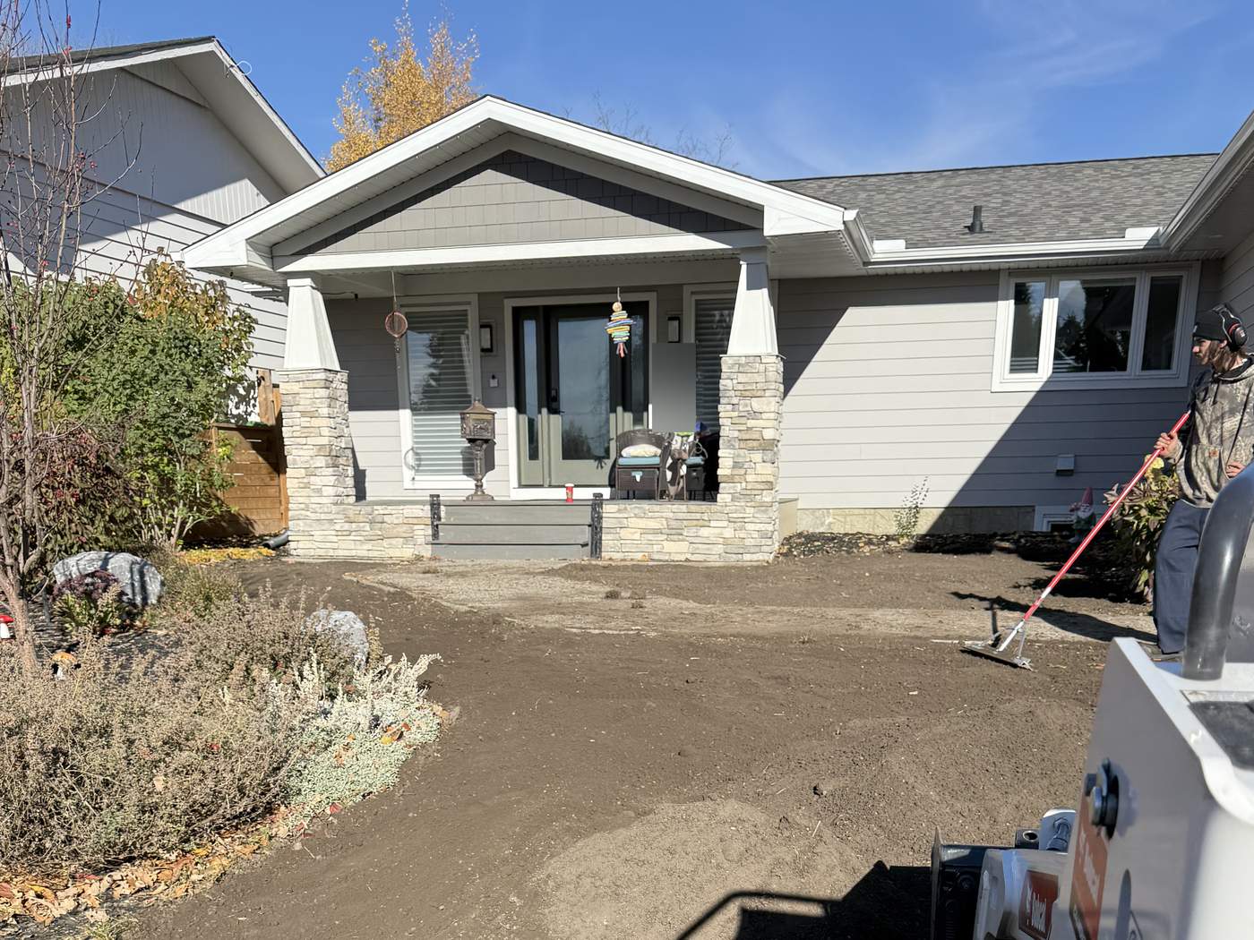 Varsity front yard with the old lawn stripped out and the ground graded, our Bobcat MT100 at the edge of the frame