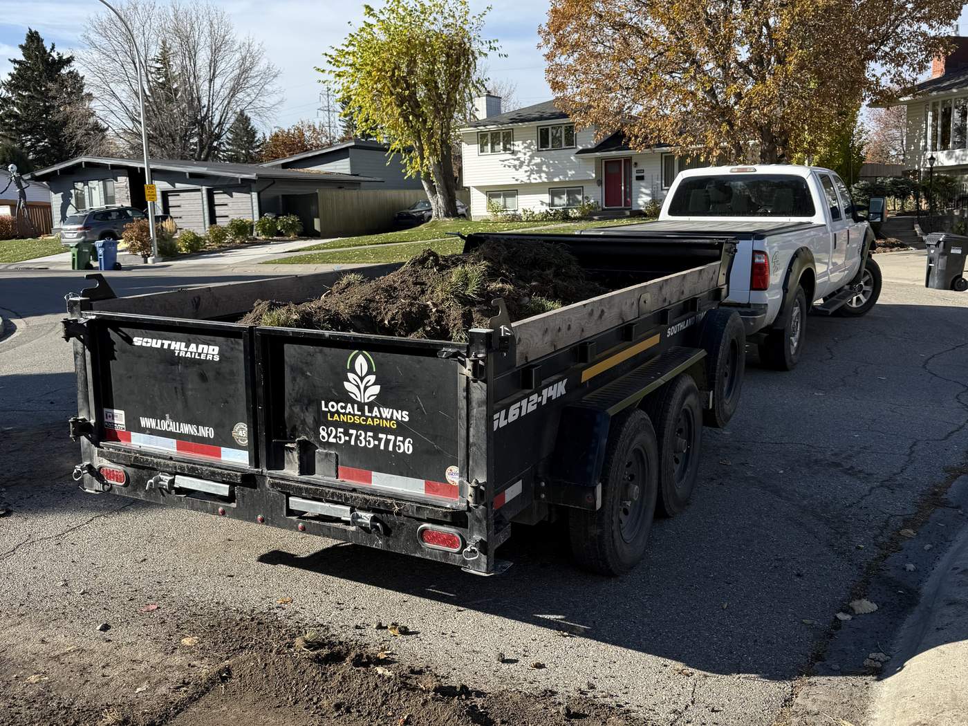 Our dump trailer parked on the street, loaded with the old sod and soil from the front lawn